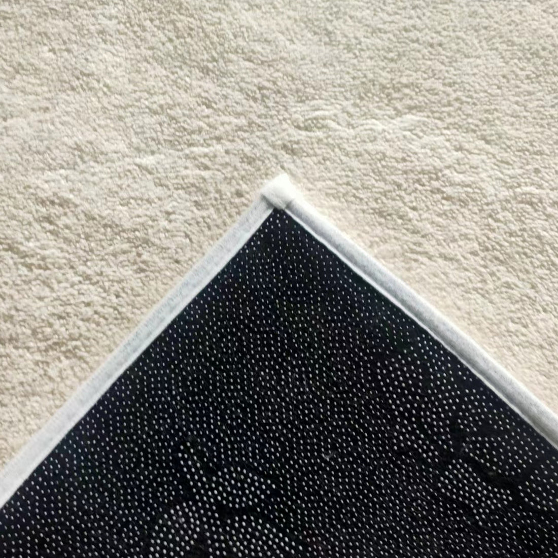 Huken 160x230cm Medium Modern Indoor Floor Rug, showcasing its non-slip backing with white grip-dots against a beige, towel-like surface. Ideal for contemporary or minimalist home decor.