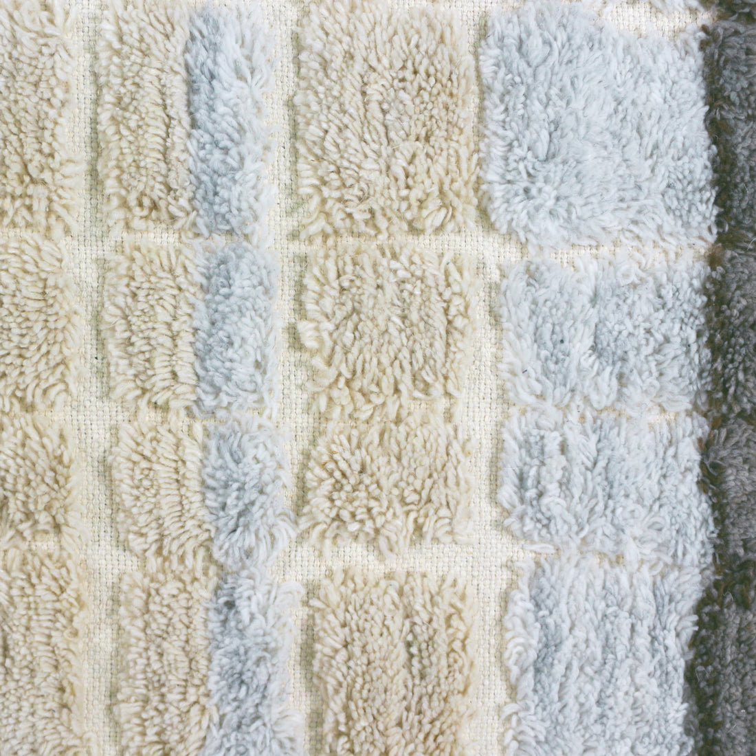 Close-up of the Isaac 120x180cm Abstract Wool Blend Handwoven Shag Rug, showcasing its textured tufted squares in a grid pattern, reflecting the intricate handwoven craftsmanship and soft plush design.