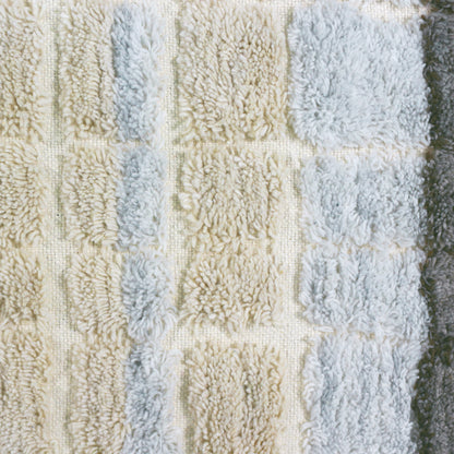 Close-up of the Isaac 120x180cm Abstract Wool Blend Handwoven Shag Rug, showcasing its textured tufted squares in a grid pattern, reflecting the intricate handwoven craftsmanship and soft plush design.