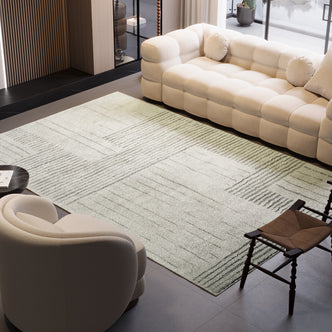 Jabeza Soft Contemporary Printed Rug 160x230cm displayed in an indoor setting, partially under a couch. The rug's modern design and soft pile add a touch of elegance and comfort to the room.