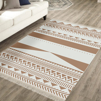 Kaley 160x230cm Woven Cotton Blend Tasseled Indoor Rug features a geometric tribal pattern with zig-zags and stripes, in warm tones, fringed edges, on a light wood-tone plank floor.