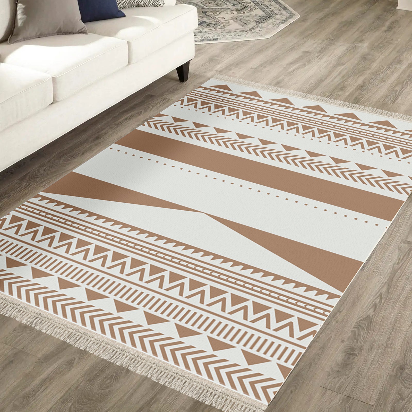 Kaley 200x300cm Woven Cotton Blend Tasseled Indoor Rug on light-wood floor, featuring cream and tan geometric tribal motifs with short fringe, under a white sofa.