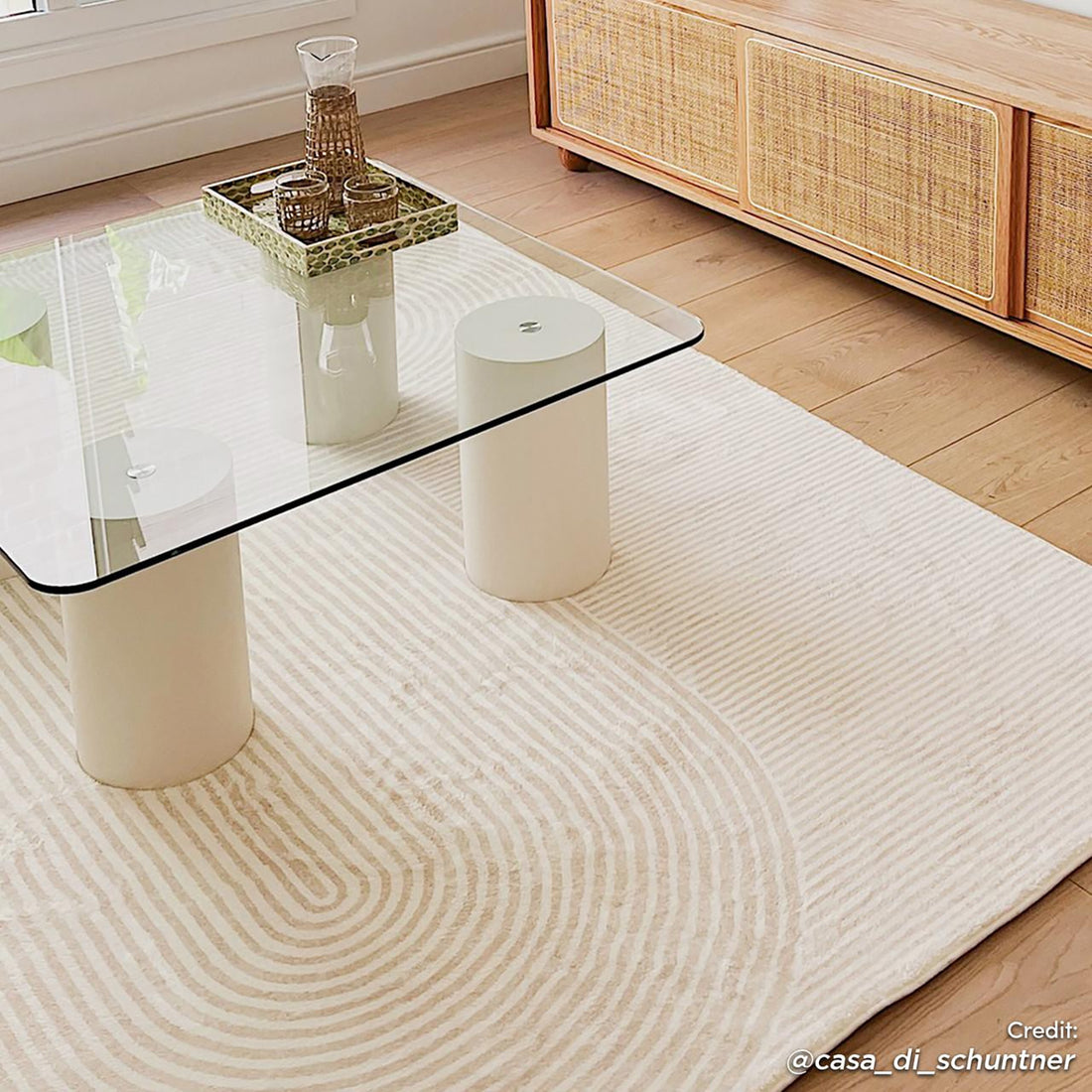 Krokom 160x230cm Modern Abstract Indoor Floor Rug under a glass-top coffee table, showcasing a subtle concentric-circle pattern, complementing a minimalist living room with light oak hardwood flooring.