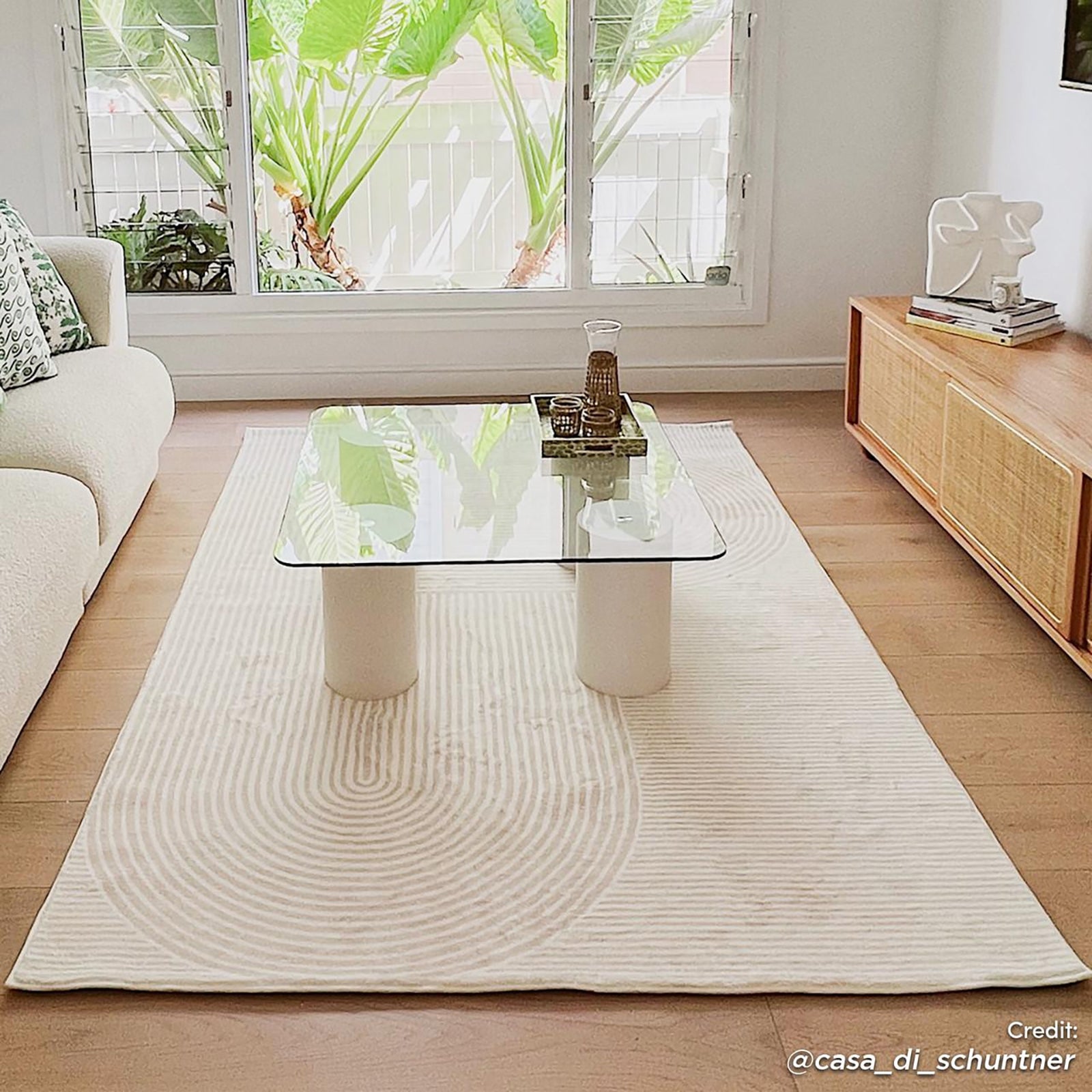 Krokom 160x230cm Modern Abstract Indoor Floor Rug under a clear glass coffee table, blending seamlessly with the minimalist living room's neutral tones and enhancing its airy, modern ambiance.