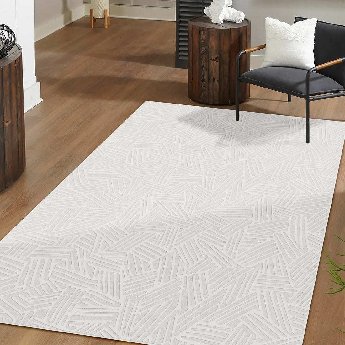 Malung 120x180cm Contemporary Indoor Floor Rug on wood floor, featuring a subtle abstract linear pattern, complements the modern armchair and side tables, creating a clean, contemporary setting.