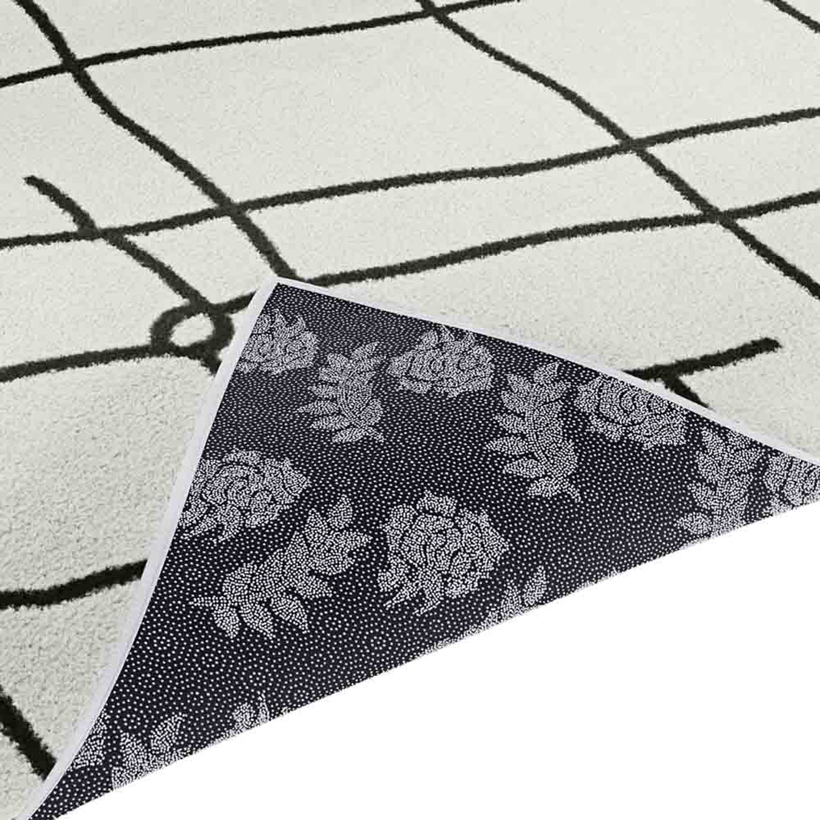 Melody Black & White Modern Rug 120x170cm, showcasing a striking Scandinavian-inspired design with black abstract lines on an ivory backdrop, ideal for adding elegance to dining or living spaces.