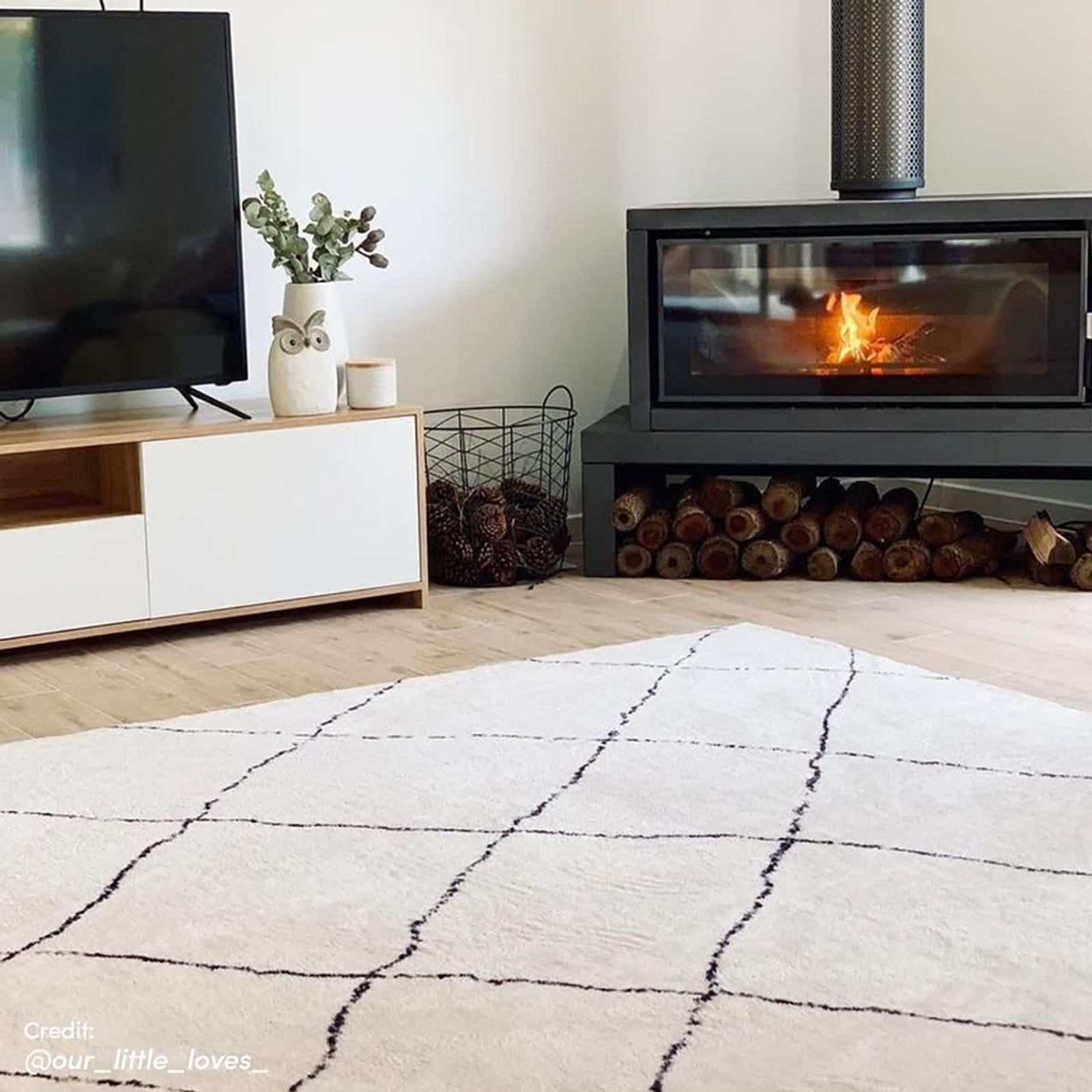 Milani 120x170cm Contemporary Printed Indoor Floor Rug with a black grid pattern on a light-cream background, enhancing a cozy living room corner with Scandinavian-inspired design.