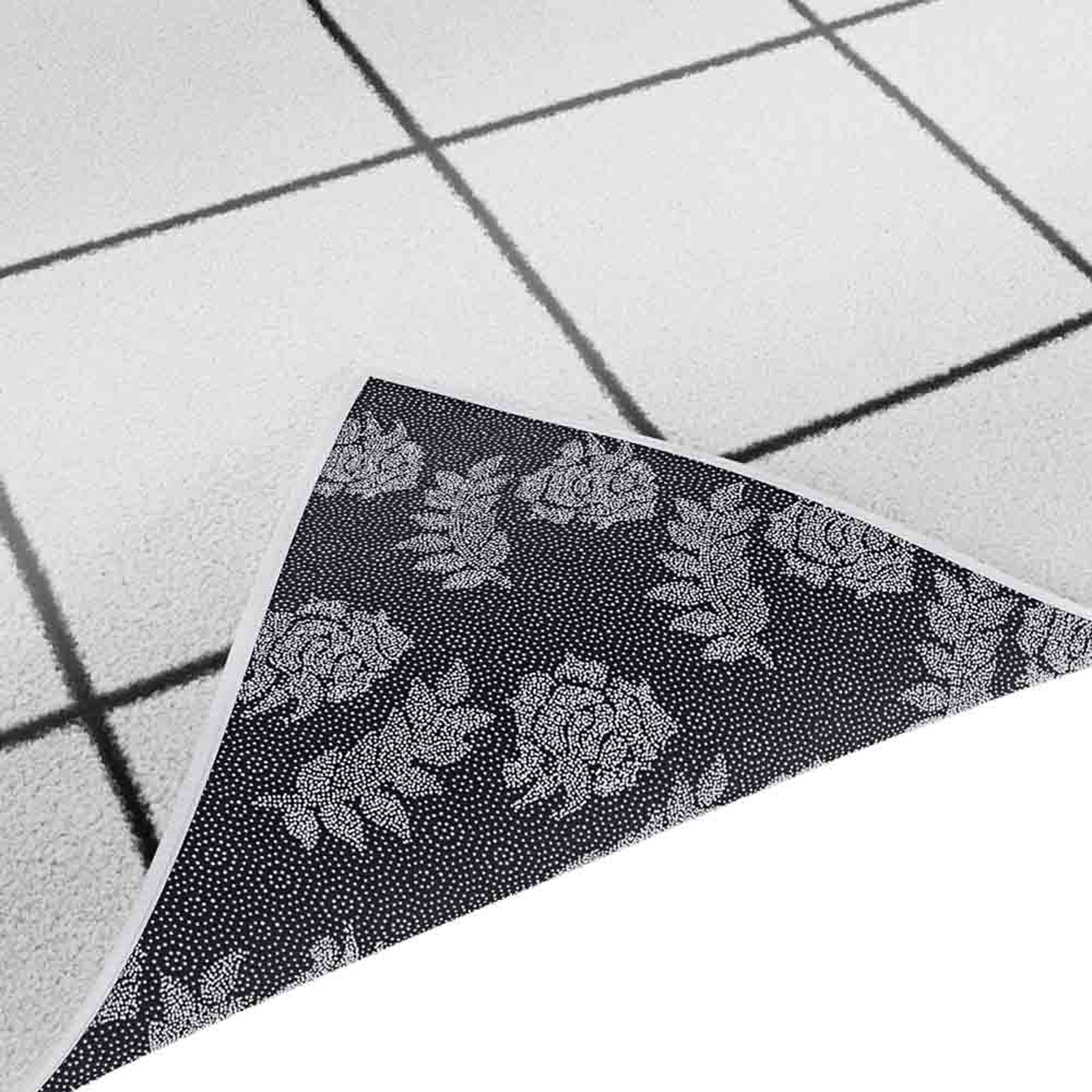 Milani 200x300cm Contemporary Printed Indoor Floor Rug with reversible sides; one light with a black grid pattern, the other dark featuring a white rose-and-leaf motif.