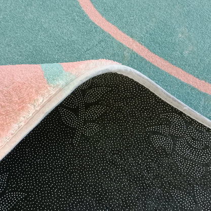 Narsen 120x170cm Kids Modern Abstract Floor Rug with pink and mint green tones, non-slip black dot-patterned backing, displayed on teal carpet with pink lines, corner flipped to show backing.