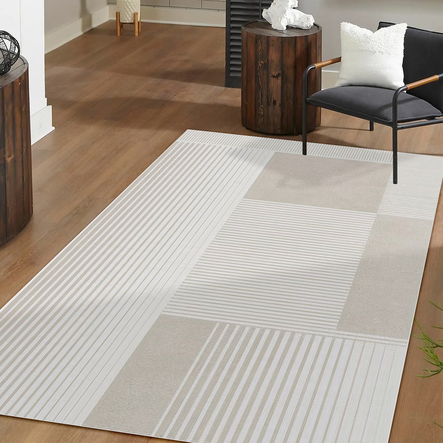 Nicho Modern Abstract Tufted Rug 160x230cm on warm wood floor, featuring neutral striped block pattern, accompanied by a black-framed armchair and rustic side tables in a softly lit corner.