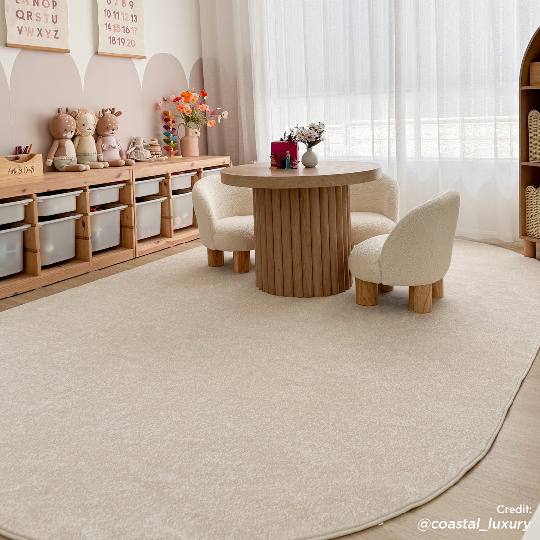 Pavla 200 x 300cm Oval Soft Rug in Cream White, centered in a children's activity corner, features a plush texture and elegant oval design, enhancing the room's cozy, modern aesthetic.
