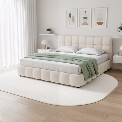 Pavla 200 x 300cm Oval Soft Rug in Cream White, plush and shaggy, lies centrally on warm wood flooring beneath a tufted cream bed, enhancing the serene, modern bedroom ambiance.