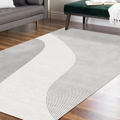 Ramvik 160x230cm Abstract Indoor Floor Rug on hardwood floor, featuring subtly textured gray lines. Nearby are a gray sofa with pillows and a dark green velvet bench with a draped white throw.