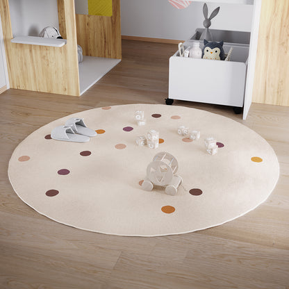 Roya 160x160cm Round Polka Dot Kids Indoor Rug on light oak floor, featuring cream with rust, mauve, tan, and brown polka dots, surrounded by gray slippers, toy blocks, and a wooden pull-along toy.