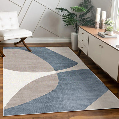 Sharya 160x230cm Abstract Indoor Floor Rug with overlapping-arc pattern in blue, beige, and off-white, placed in a modern room, complemented by a console, lounge chair, and potted plants.