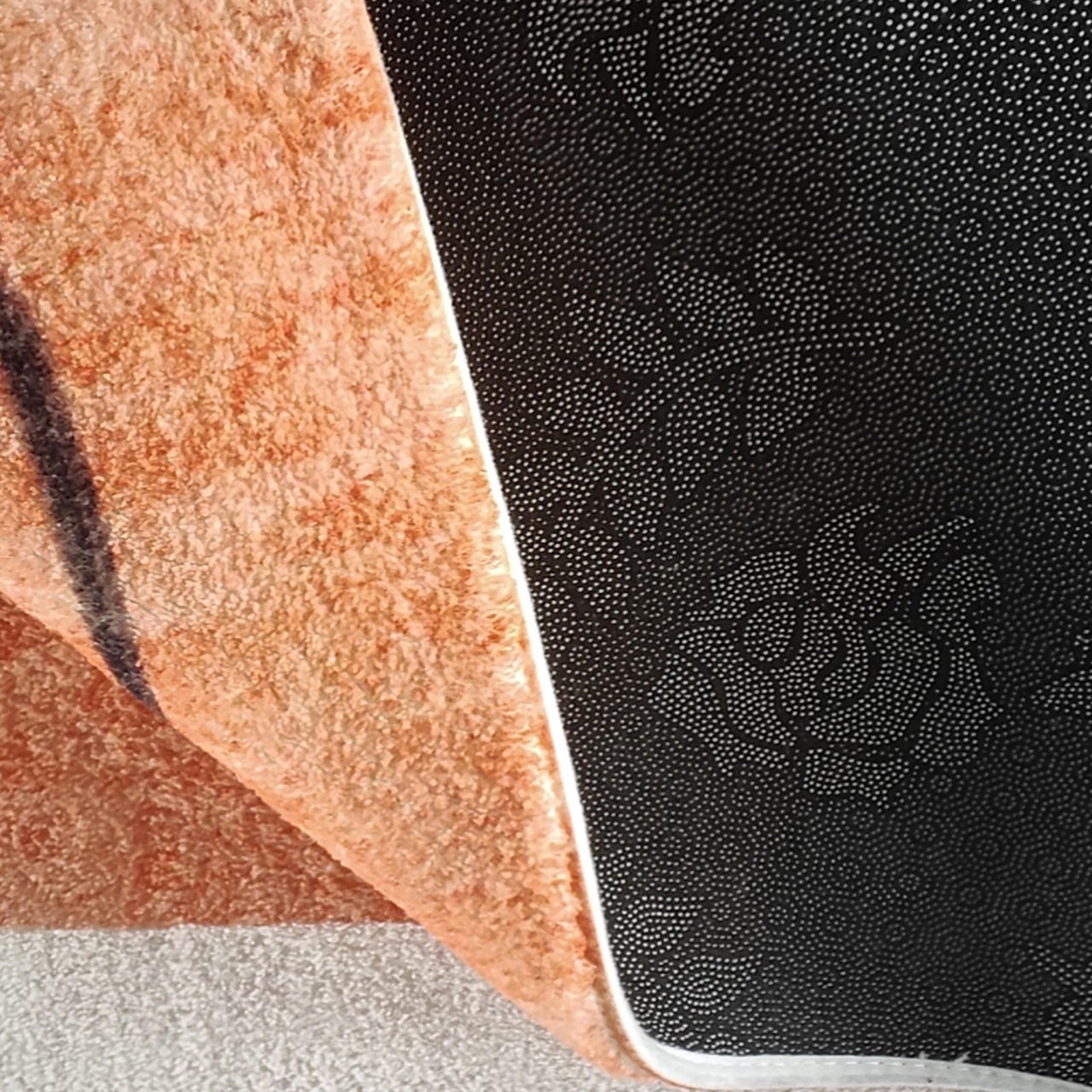 Close-up of the Skalo 160x230cm Medium Contemporary Colourful Kids Indoor Rug, showcasing plush orange fabric with non-slip black backing, highlighting the rug's texture and safety features.