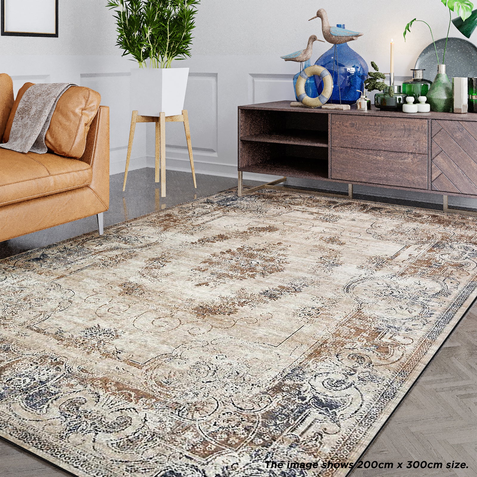 Vikene Distressed Persian Silky Floor Rug 200 x 300 cm, displayed in a cozy living room with a caramel-tan sofa, mid-century plant stand, and dark-wood console with decorative accents.