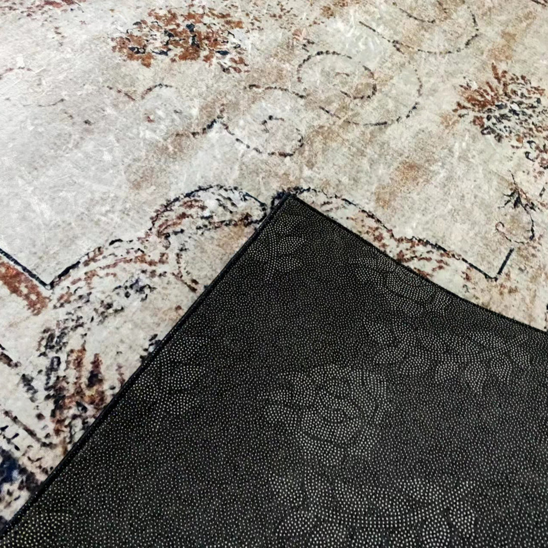 Vikene Distressed Persian Silky Floor Rug 120 x 170cm, featuring a light-toned abstract pattern with a flipped corner, revealing a dark, textured non-slip backing for secure placement.