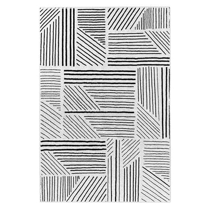Vikki 120x170cm Small Abstract Contemporary Floor Rug features a black-and-white geometric grid of rectangular and triangular blocks with parallel lines, creating a modern patchwork pattern.