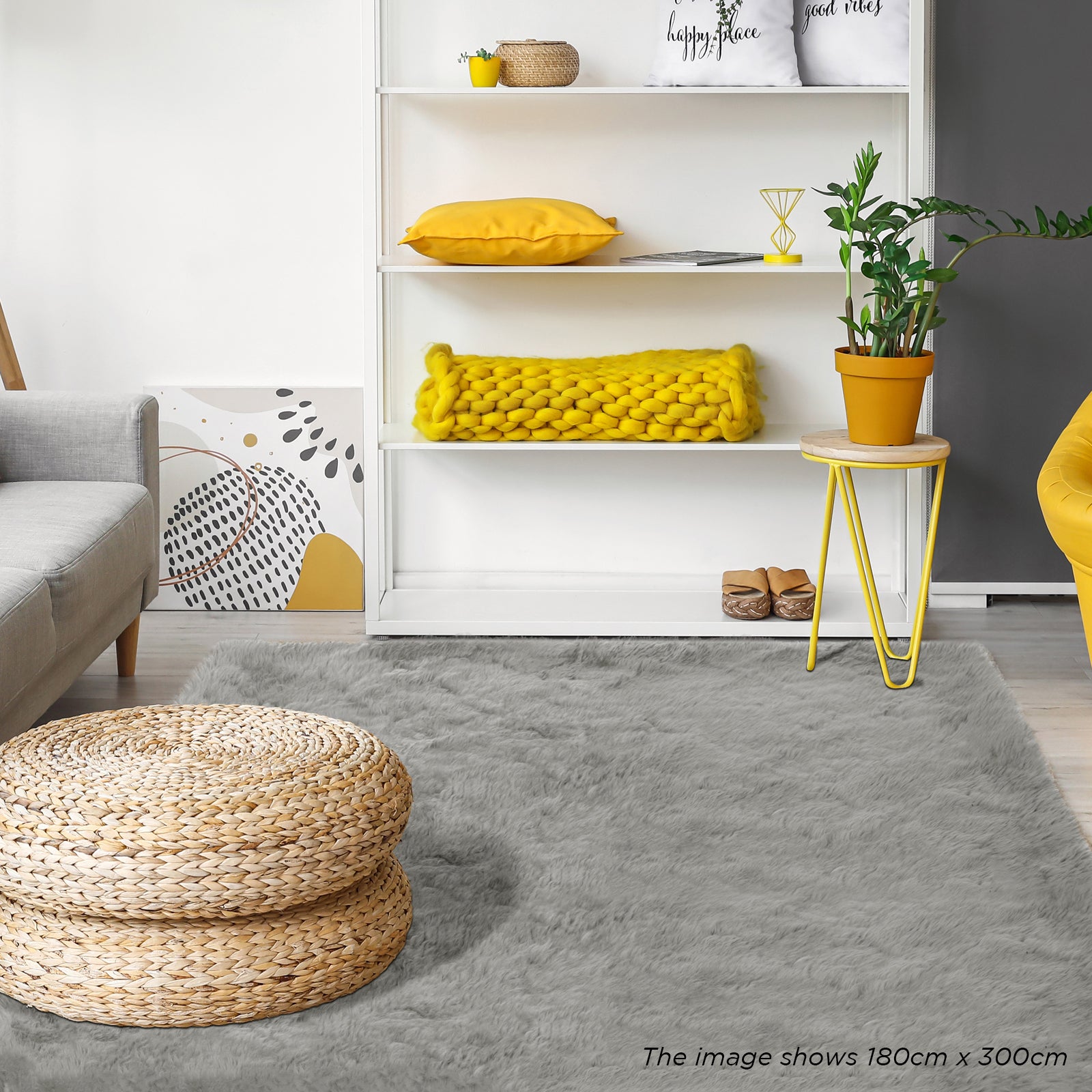 Zubuin 180x300cm Shaggy Plush Rectangular Rug in Grey, displayed in a modern living room setting with a woven rattan pouf, gray sofa, shelving with decor, and yellow accents.
