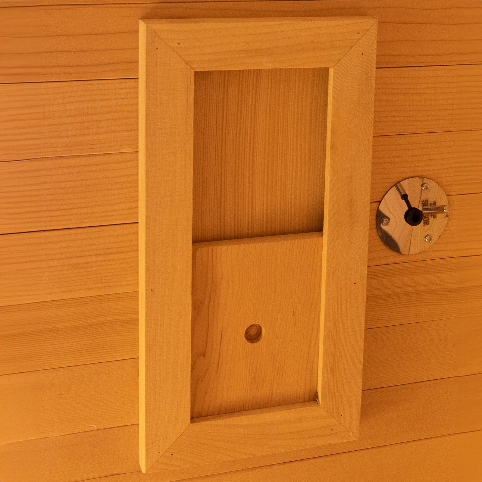 Harlow 1 Person Canadian Hemlock Infrared Home Sauna installation in progress with wood-paneled wall featuring cut-outs for fixtures, including a recessed rectangular opening and a round metal mounting plate.