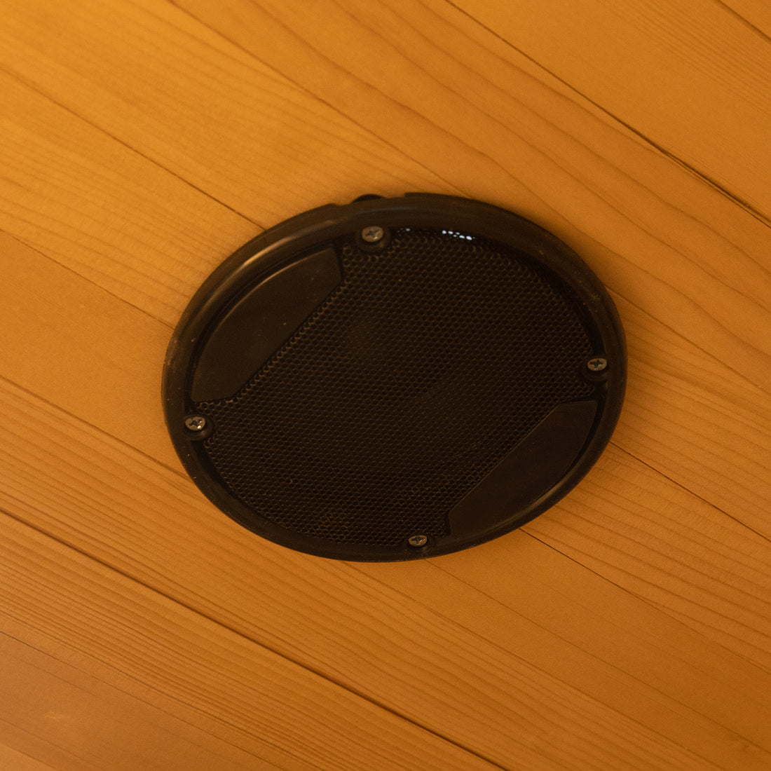 Harlow 1 Person Canadian Hemlock Infrared Home Sauna with a black metal-mesh grille speaker set flush in a wooden ceiling, showcasing its built-in audio feature for a relaxing sauna experience.