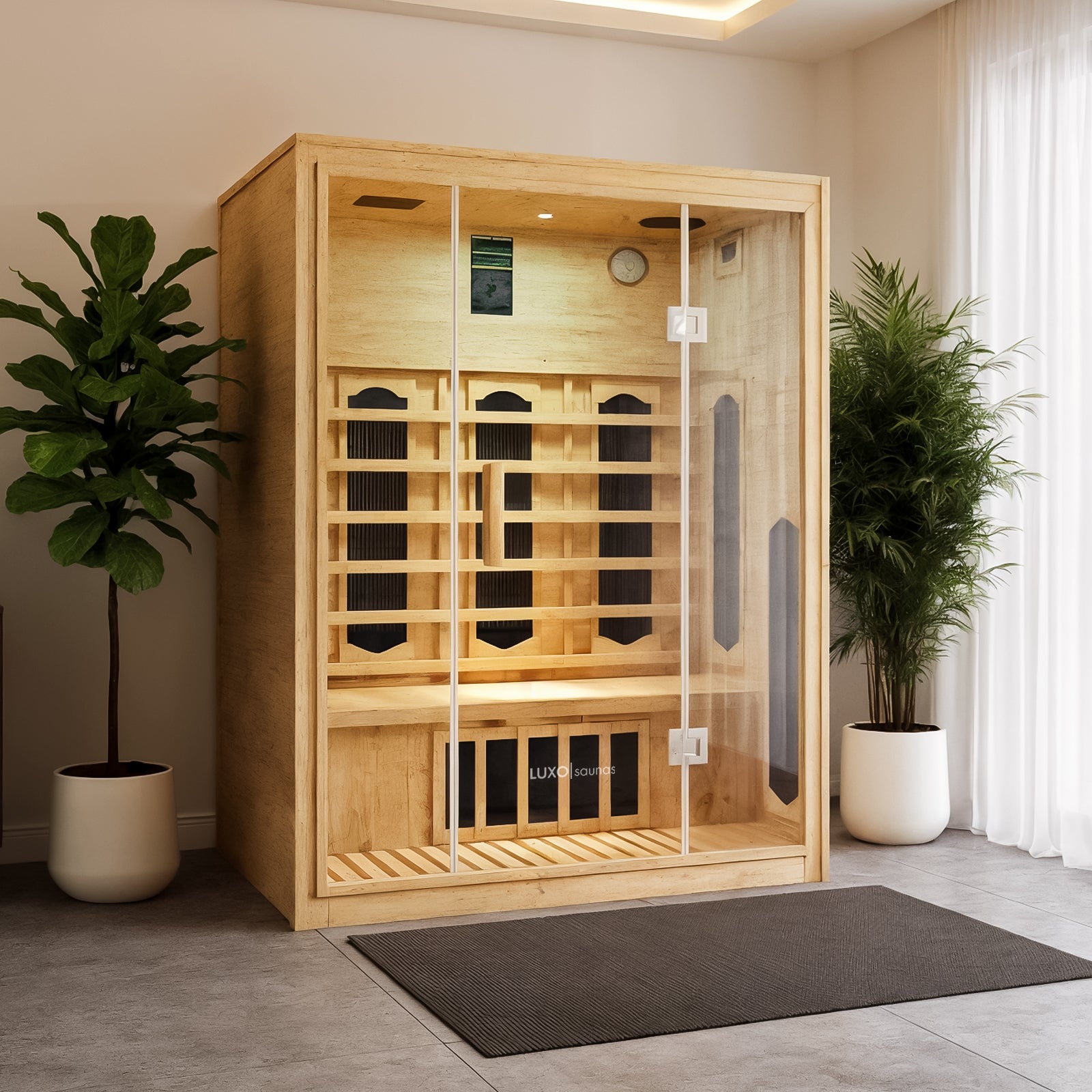 Helle 2-Person Hybrid Infrared Indoor Home Sauna: Light-toned wood, glass doors, built-in heating panels, seating bench, digital control panel, clock. Flanked by plants, spa-like ambiance.
