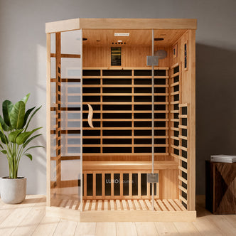 Helle 3 Person Carbon Fibre Infrared Indoor Home Sauna features a light wood cabin with a tempered-glass door, wooden bench, and LUXO saunas label, set in a minimalist interior with a potted plant nearby.