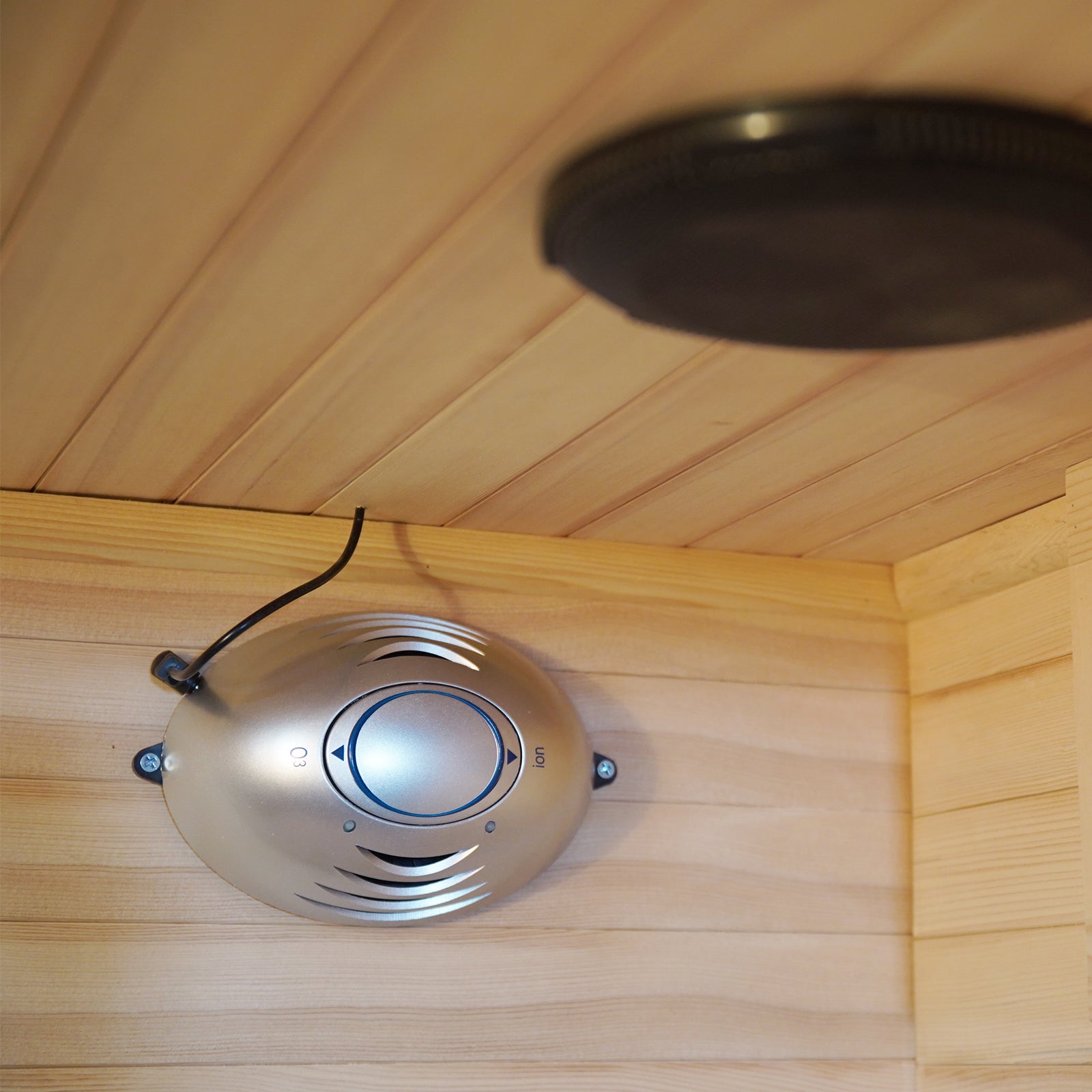 Hirsi 2 Person Carbon Fibre Infrared Indoor Home Sauna featuring a silver-colored ozone/ion air-purifier module with “O3” and “Ion” markings, mounted on light wood paneling, enhancing air quality within the sauna.