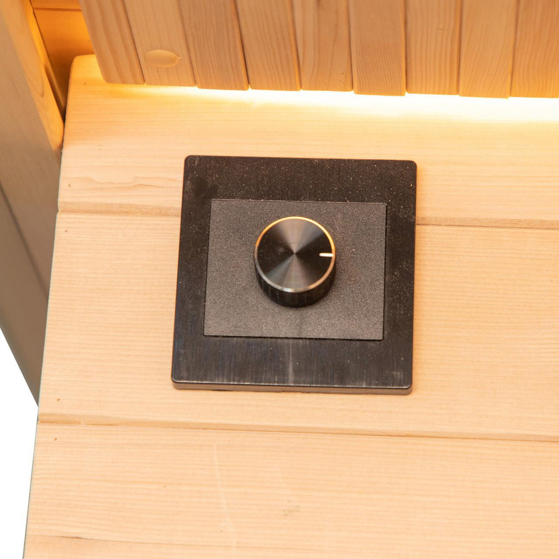 The Hoito 4-Person Full Spectrum Infrared Sauna features a flush-mounted black rotary control on a wooden panel, enhancing its sleek, modern design for personalized light and temperature adjustments.