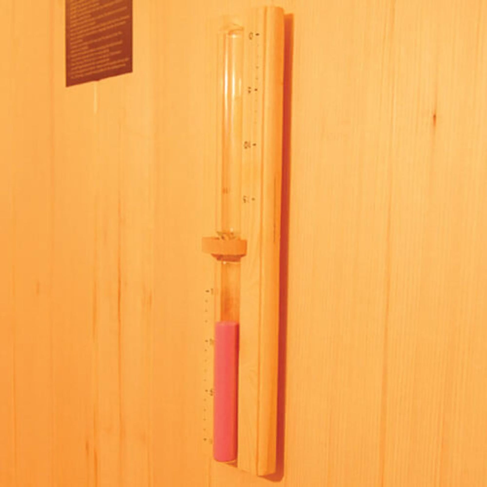 Wall-mounted hourglass with pink sand, on wooden backing. Complements the Kivi 3-Person Traditional Stove Finnish Indoor Home Sauna, enhancing the sauna's timing for optimal relaxation sessions.