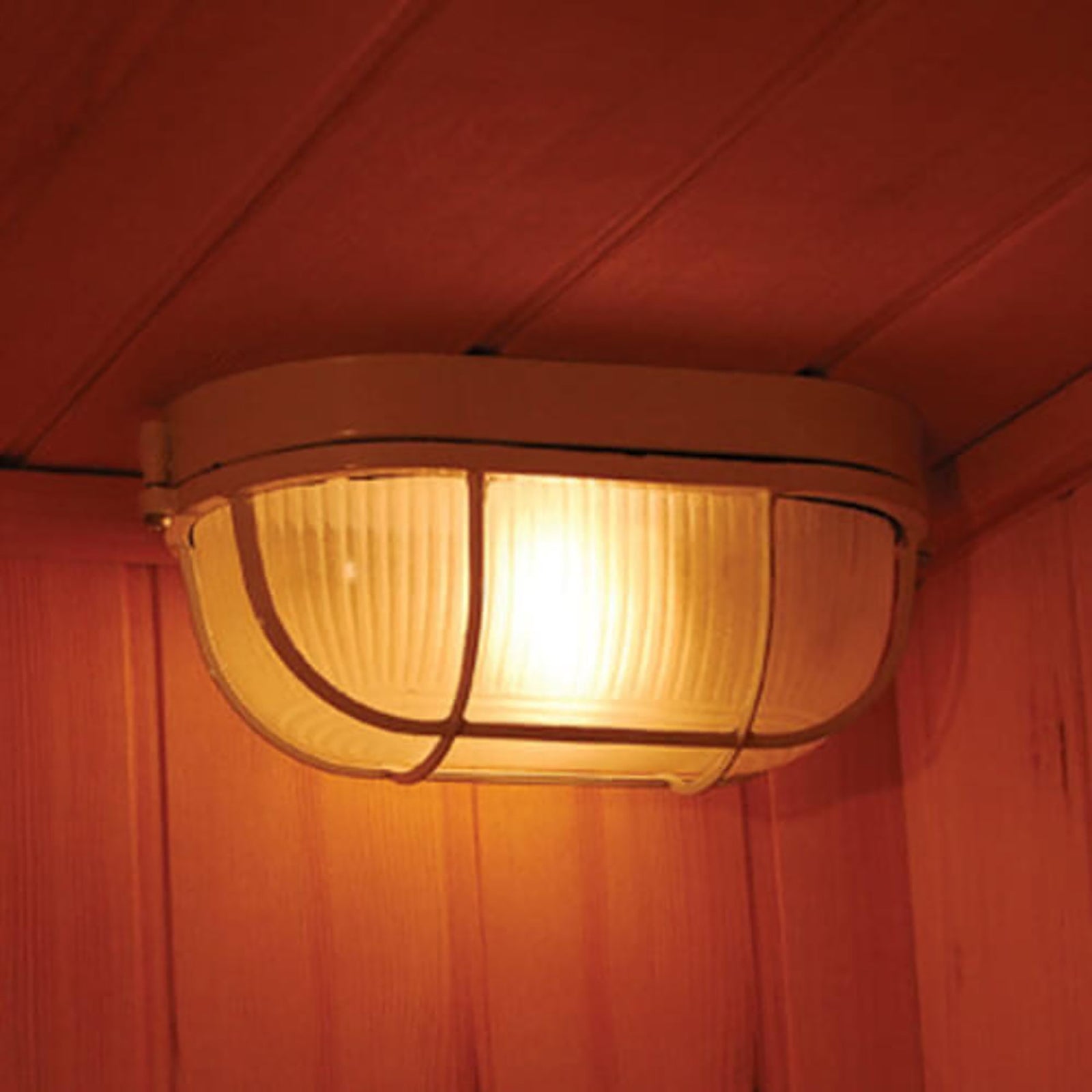 Kivi 3-Person Traditional Stove Finnish Indoor Home Sauna featuring a flush-mounted, ribbed-glass lamp with a protective metal cage in a wood-paneled room, enhancing relaxation and sauna ambiance.