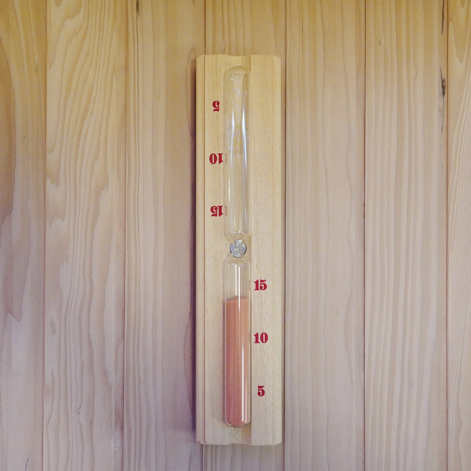 Loyly 3 Person Traditional Finnish Indoor Home Sauna features a mounted 15-minute sand timer with red sand on a wooden backing, designed for time-keeping in steam or sauna sessions.