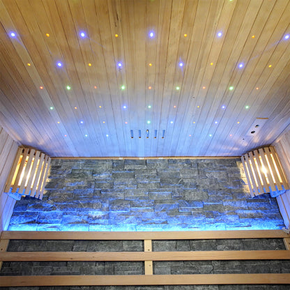 Loyly 3-Person Traditional Finnish Indoor Home Sauna featuring a stone wall with blue LED accents, wooden bench seating, and a star-field effect ceiling, creating a luxurious, calming atmosphere.