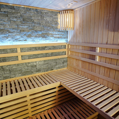 Loyly 3 Person Traditional Finnish Indoor Home Sauna features wood-lined interior, slatted benches, stone accent wall, and wall-mounted light, creating a luxurious and calming sauna experience.