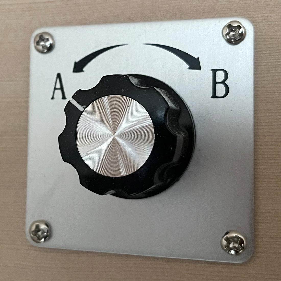 Close-up of a panel-mounted rotary selector switch for the Lue 2 Person Full Spectrum Curved Infrared Indoor Home Sauna, featuring a black knob with position indicators A and B on a metal faceplate.