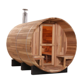 Luola 4-Person Red Cedar Barrel Sauna with Wood Stove: A wooden barrel-shaped sauna featuring a silver dispenser container and wooden bench, ideal for outdoor relaxation and wellness.