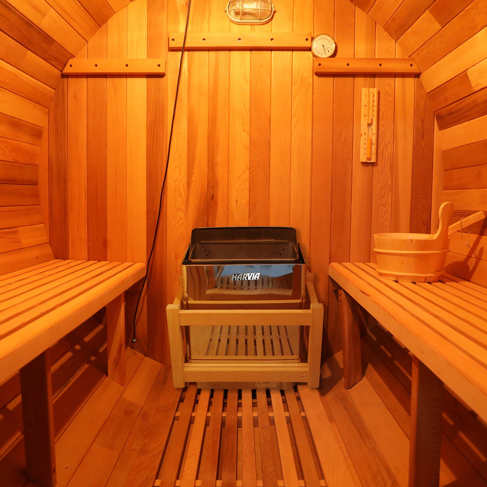 Close-up of the Luola 2-Person Red Cedar Barrel Sauna with Harvia Heater, highlighting its wooden texture and barrel design, showcasing luxury and wellness for outdoor relaxation.