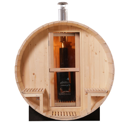 Luola 2 Person Pine Outdoor Barrel Sauna & Wood Stove features a wooden barrel shape, glass-paneled door, interior bench seating, and a stainless-steel chimney for the wood-burning stove, offering traditional sauna relaxation.