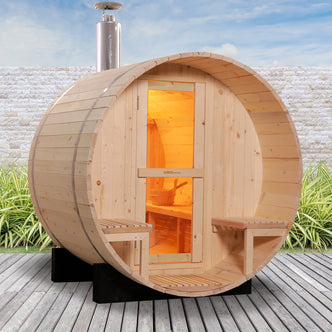 Luola 2 Person Pine Outdoor Barrel Sauna & Wood Stove on deck, featuring wooden slats, glass-paneled door, stainless-steel chimney, and built-in porch seating, ideal for backyard relaxation.