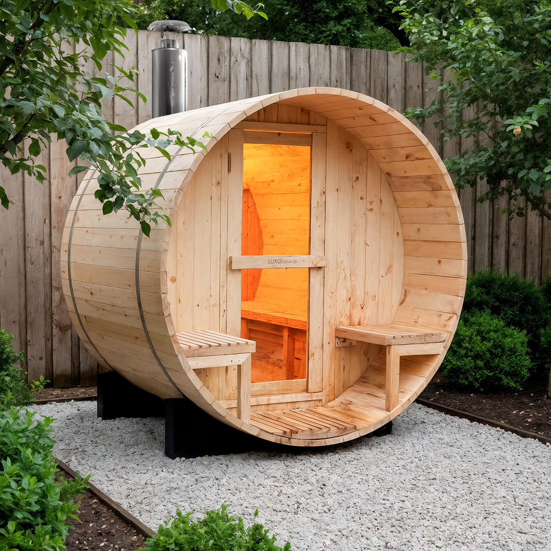 Luola 2 Person Pine Outdoor Barrel Sauna & Wood Stove shown in a backyard on gravel, with a glass-paneled door, warm interior, and wooden benches, enhancing relaxation and wellness.