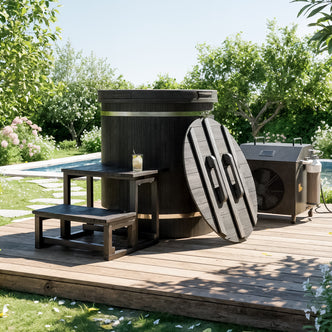 Noni 1-Person Outdoor Ice Bath with 1HP Chiller in Black is a round, dark-stained wooden hot tub. It features a matching cover, small bench, side table with a cold drink, and a compact chiller unit.