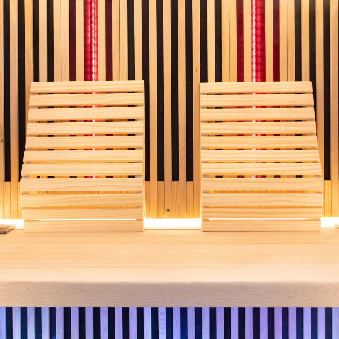 Close-up of the Runko 2 Person Canadian Hemlock Carbon Fibre Infrared Sauna, showcasing its smooth hardwood surface, featuring wooden slats and chairs, highlighting the sauna's craftsmanship and indoor elegance.