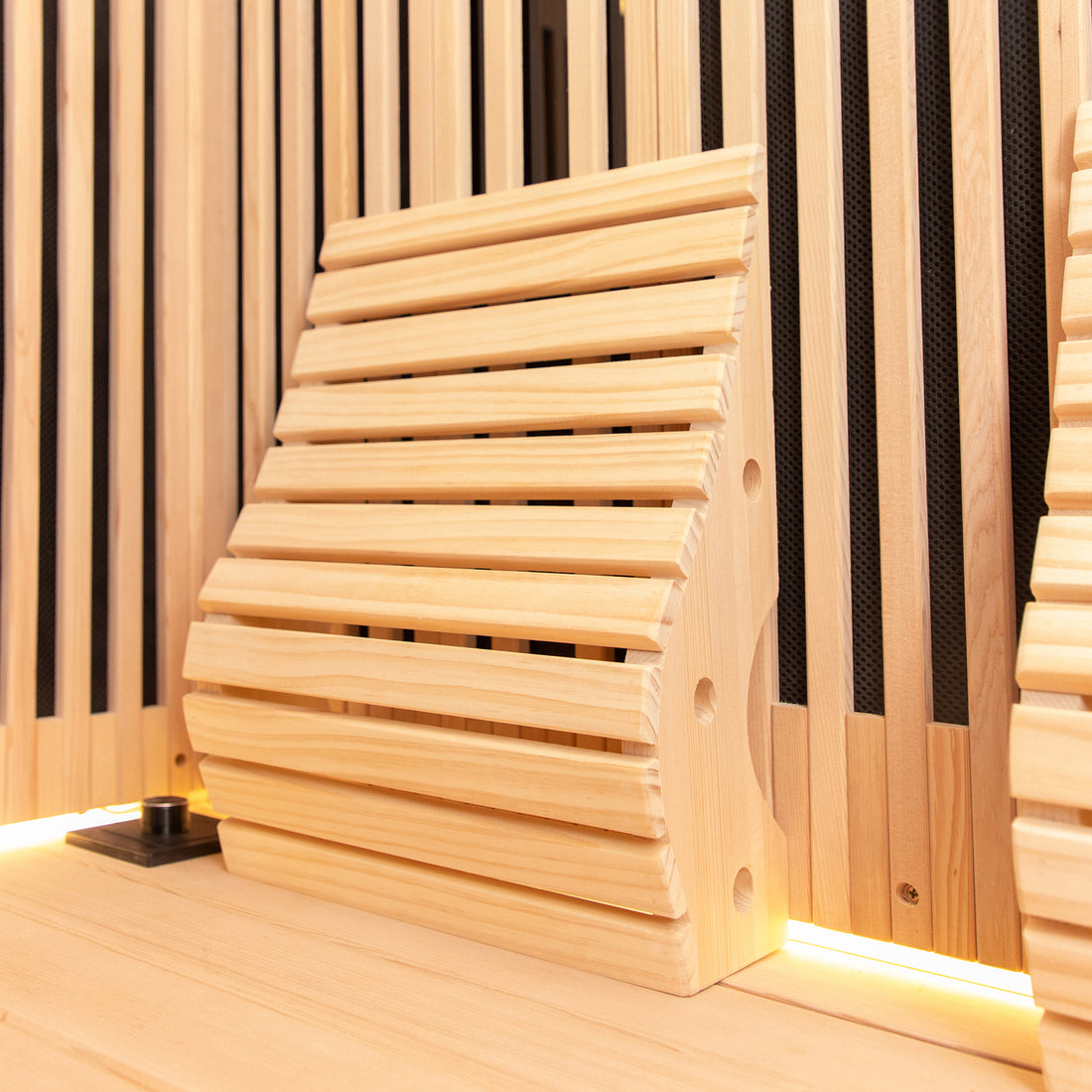 Close-up view of the Runko 2 Person Canadian Hemlock Carbon Fibre Infrared Sauna, highlighting its sleek black cylindrical controls set against a finely crafted wooden surface, emphasizing high-quality lumber craftsmanship.