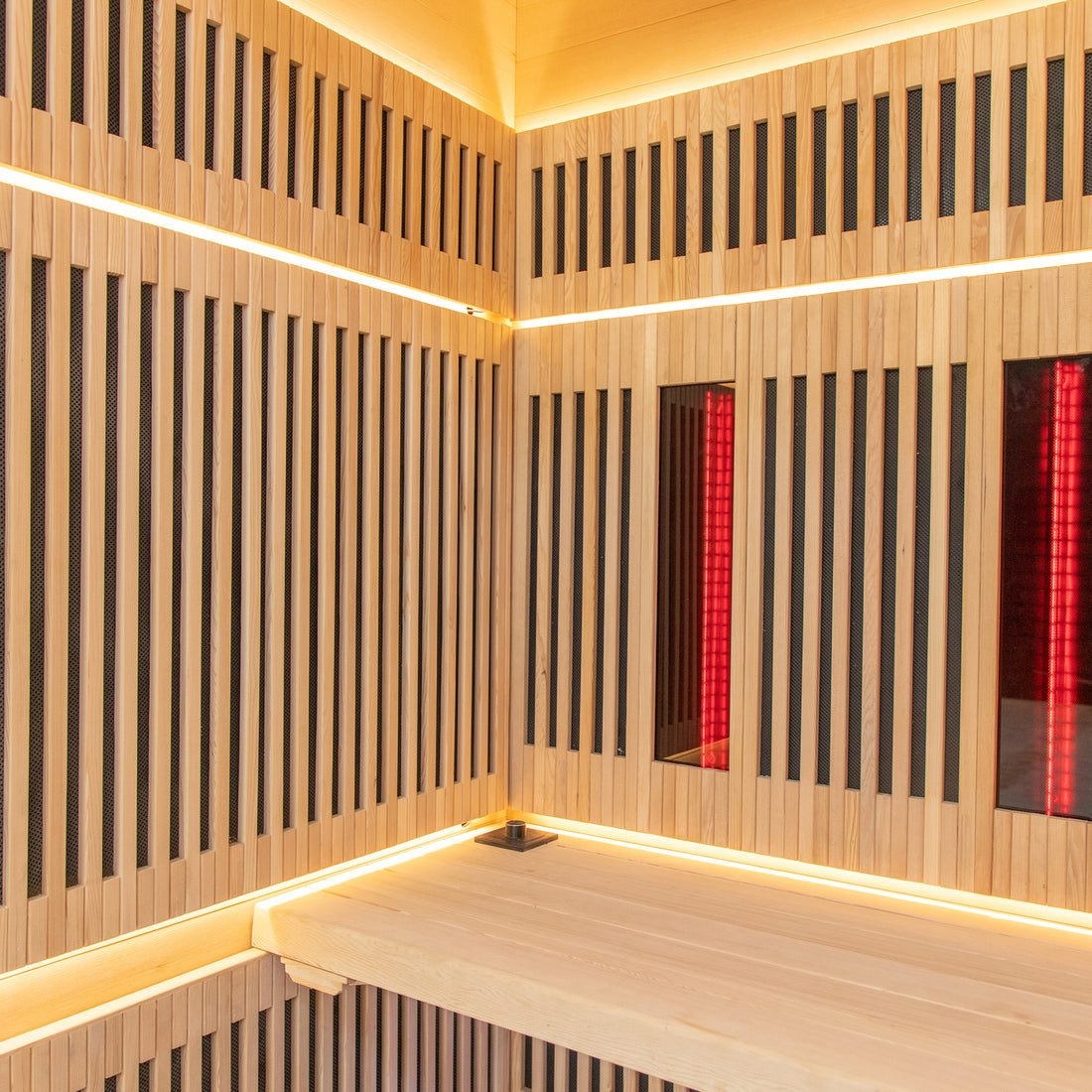 Runko 2 Person Canadian Hemlock Carbon Fibre Infrared Sauna featuring wood-paneled walls with integrated red lighting, showcasing a close-up of the polished wooden surface and interior design elements.