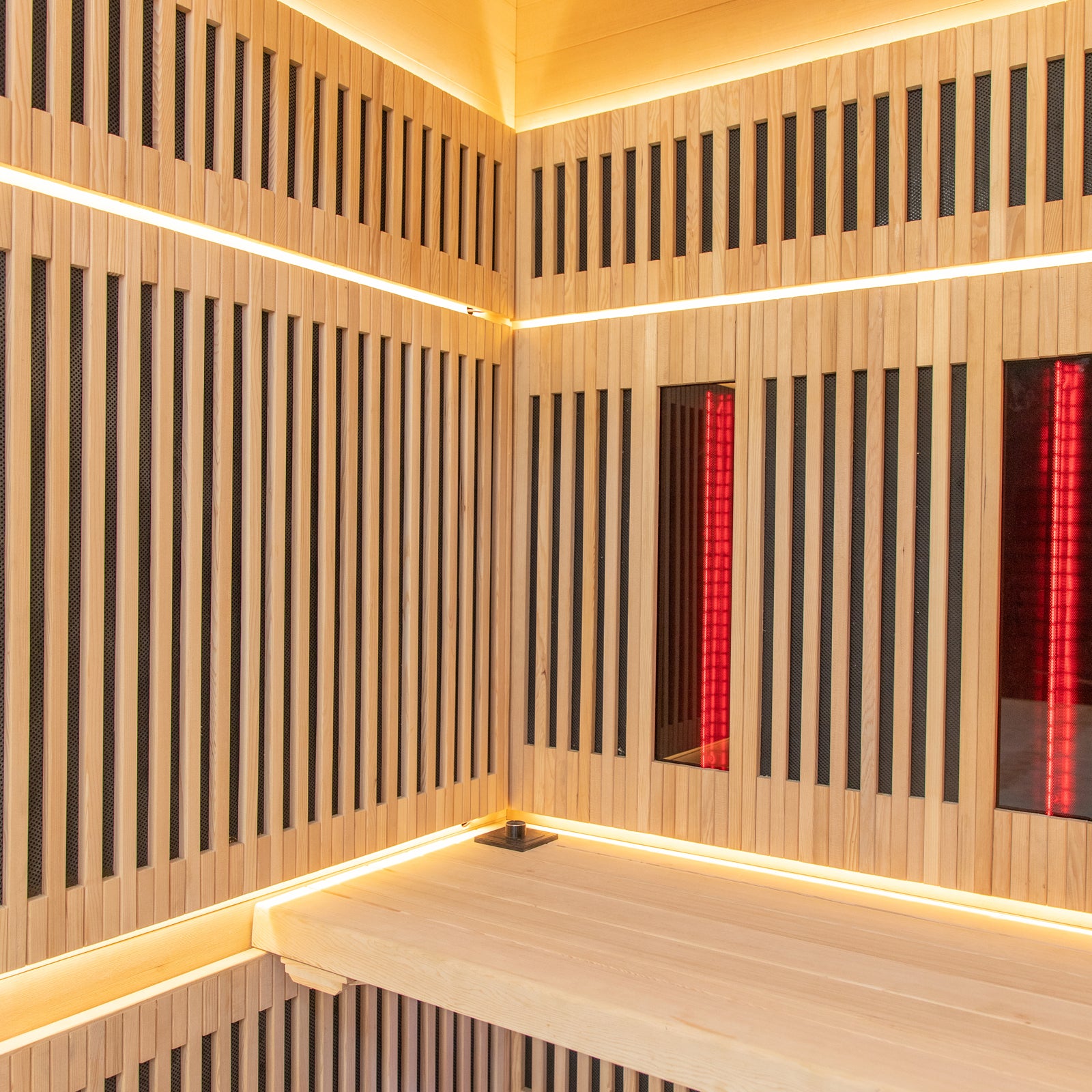Runko 2 Person Canadian Hemlock Carbon Fibre Infrared Sauna featuring wood-paneled walls with integrated red lighting, showcasing a close-up of the polished wooden surface and interior design elements.