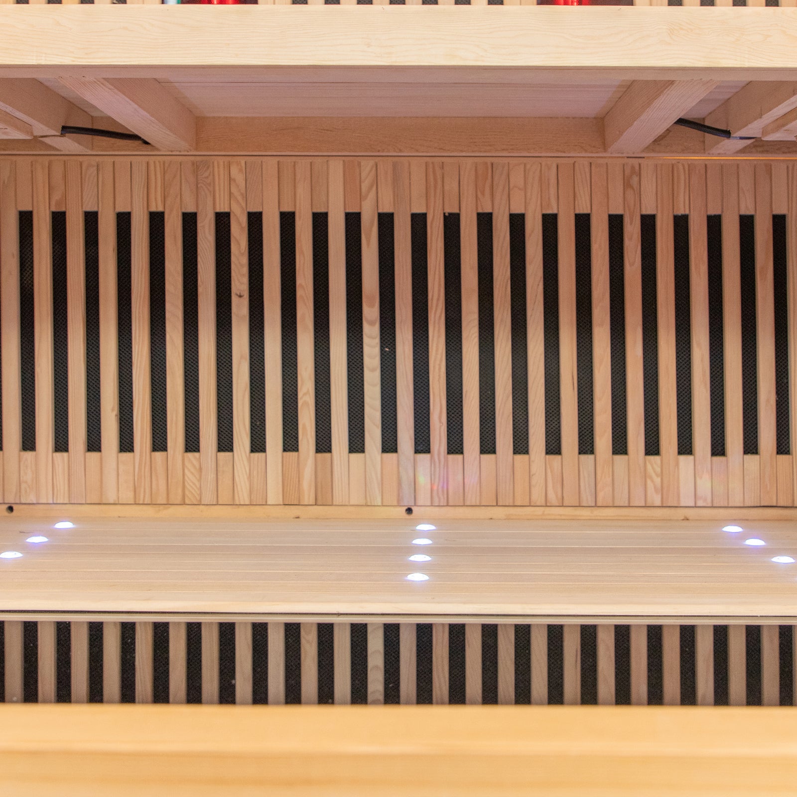 Runko 2 Person Canadian Hemlock Carbon Fibre Infrared Sauna displayed on a smooth wooden surface, highlighting its sleek design and premium materials, ideal for indoor relaxation and wellness.