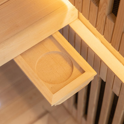 Runko 2 Person Canadian Hemlock Carbon Fibre Infrared Sauna showcased with its smooth, circular wooden exterior, highlighting craftsmanship in woodworking with visible hemlock grain, set on a sturdy wooden shelf.
