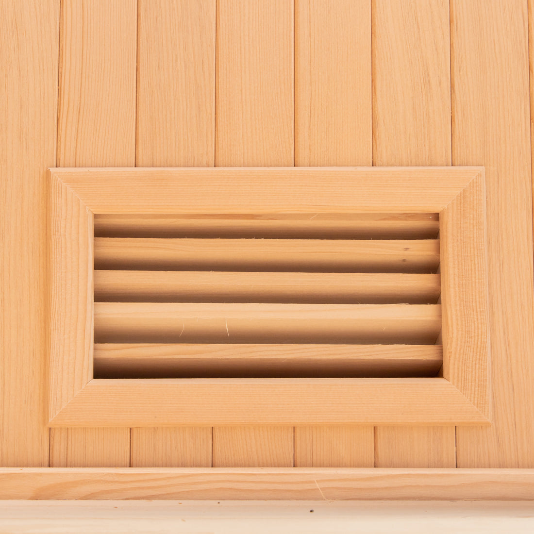 Close-up of the Tarve 3 Person Canadian Hemlock Sauna with Harvia Stove, highlighting the smooth hardwood planks and precise craftsmanship of the wooden surface, emphasizing its sturdy and elegant design.