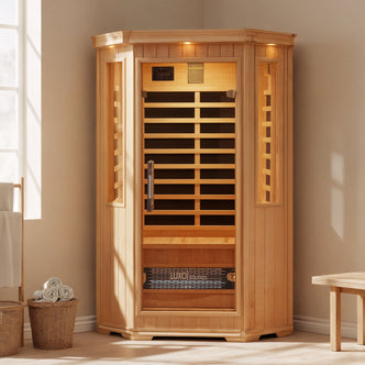 Tukeva 2-Person Carbon Fibre Infrared Indoor Home Sauna in a bright, minimalist room with glass doors, side windows, and a glowing interior, surrounded by towels and simple wooden furnishings.